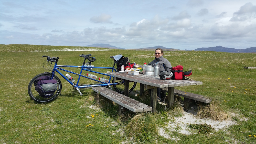 Another photo of a windswept tandemist enjoying a picnic lunch, this time on the South Uist machair